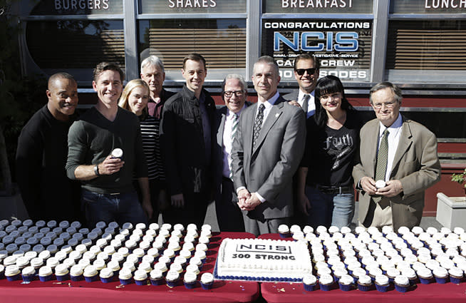 The NCIS team celebrates their 300th episode. (L-R): Series regulars Brian Dietzen, Rocky Carroll, Mark Harmon, Emily Wickersham, Sean Murray, EP Gary Glasberg, director Andrew Traver, Michael Weatherly, Pauley Perrette, David McCallum. Photo: Sonja Flemming/CBS