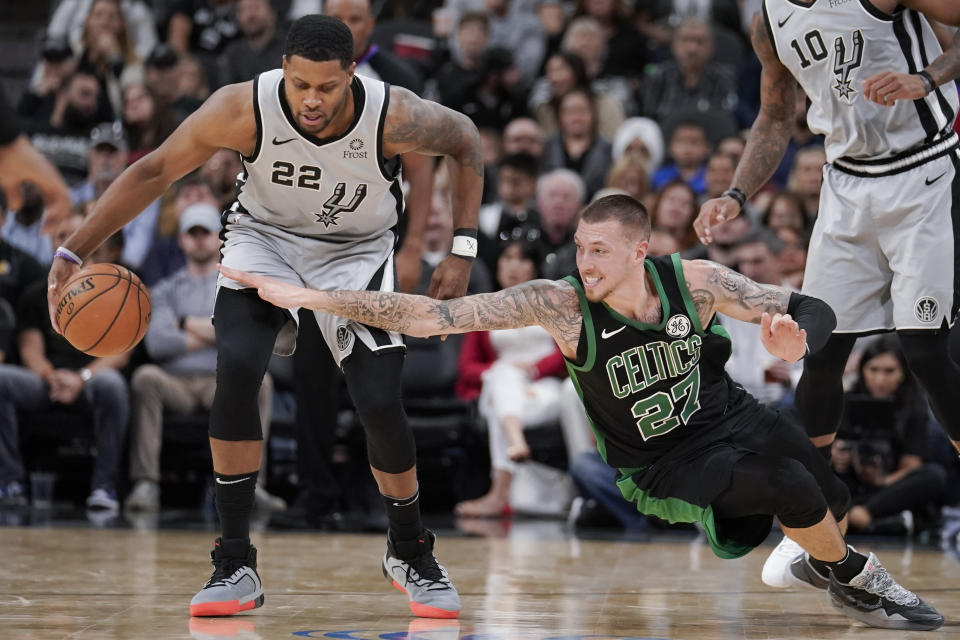 San Antonio Spurs' Rudy Gay (22) beats Boston Celtics' Daniel Theis for possession during the first half of an NBA basketball game, Saturday, Nov. 9, 2019, in San Antonio. (AP Photo/Darren Abate)