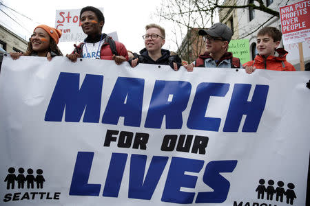 High school students carry a banner during a "March for Our Lives" demonstration demanding gun control in Seattle, Washington, U.S. March 24, 2018. REUTERS/Jason Redmond