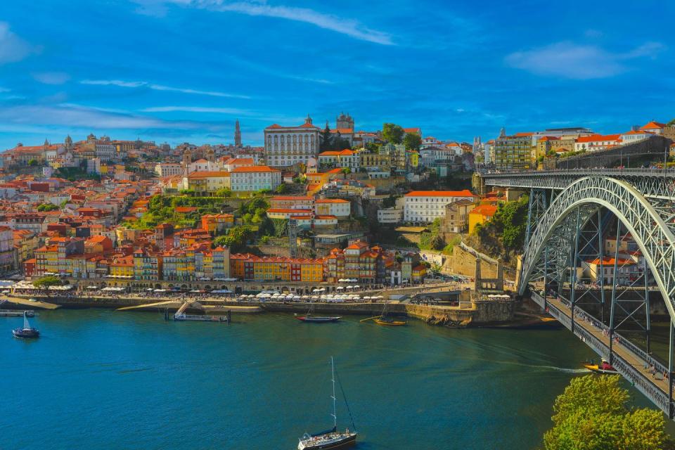 view of the buildings with typical architecture on the douro river with dom luis i bridge in porto