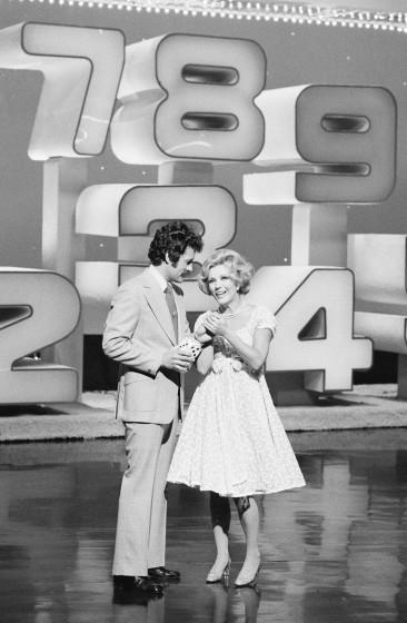 HIGH ROLLERS -- Pictured: (l-r) Host Alex Trebek, dice girl Ruta Lee (Photo by NBCU Photo Bank/NBCUniversal via Getty Images via Getty Images)