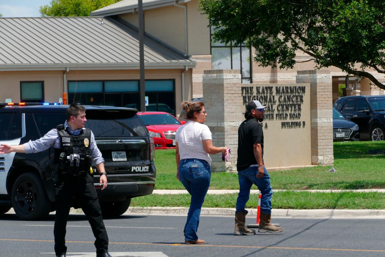 A law enforcement officer helps people cross the street at Uvalde Memorial Hospital after a shooting was reported earlier in the day at Robb Elementary School, Tuesday, May 24, 2022, in Uvalde, Texas. 