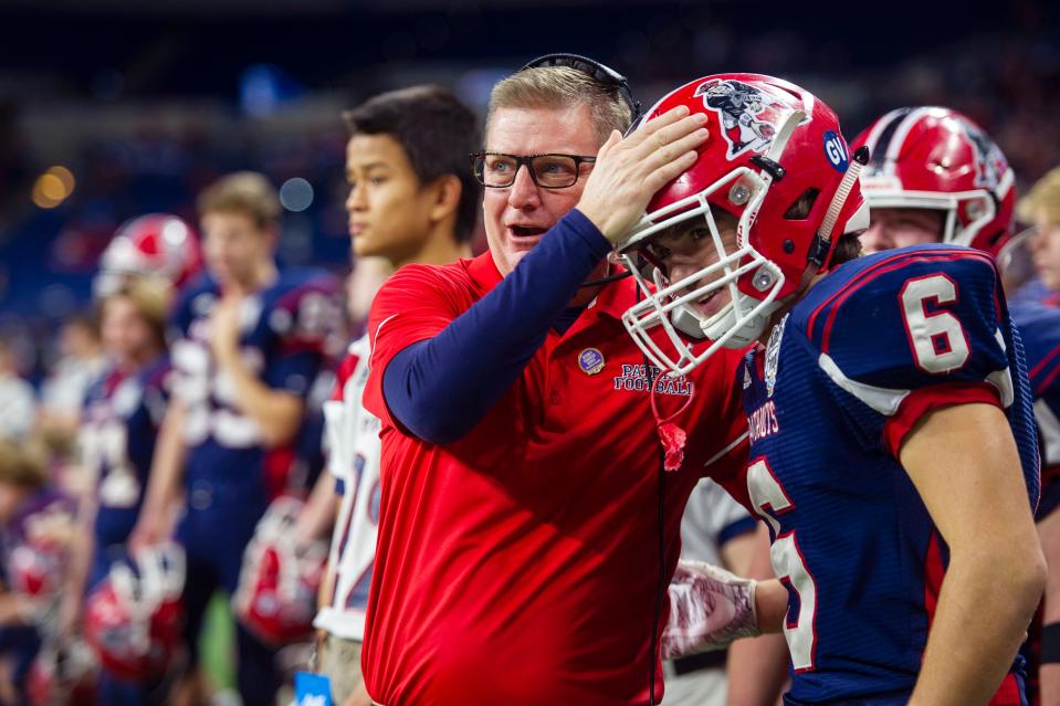 Head Coach Todd Wilkerson supports Heritage Hills' Gavin Vaal (6) after he comes off the field at the Heritage Hills vs Bishop Chatard IHSAA State Football Game at Lucas Oil Stadium in Indianapolis, Ind., Friday, Nov. 29, 2019.