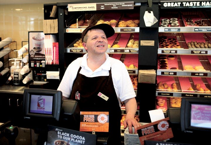 Hank Lawler greets customers at the Dunkin' Donuts on Broadway in Newport in 2012. While the Broadway Dunkin' has since closed the chain can be found throughout Aquidneck Island.
