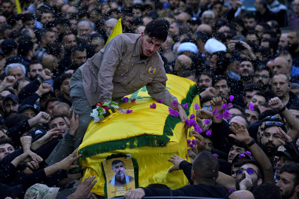 Ali, son of Abbas Mohammed Raad, the son of the head of Hezbollah's parliamentary bloc, Mohammed Raad, who was killed by an Israeli strike, sits on top of his father's coffin during his funeral procession in the southern town of Jbaa, Lebanon, Thursday, Nov. 23, 2023. The militant Hezbollah group fired more than 50 rockets at military posts in northern Israel on Thursday, a day after an Israeli airstrike on a home in southern Lebanon killed five of the group's senior fighters. (AP Photo/Bilal Hussein)