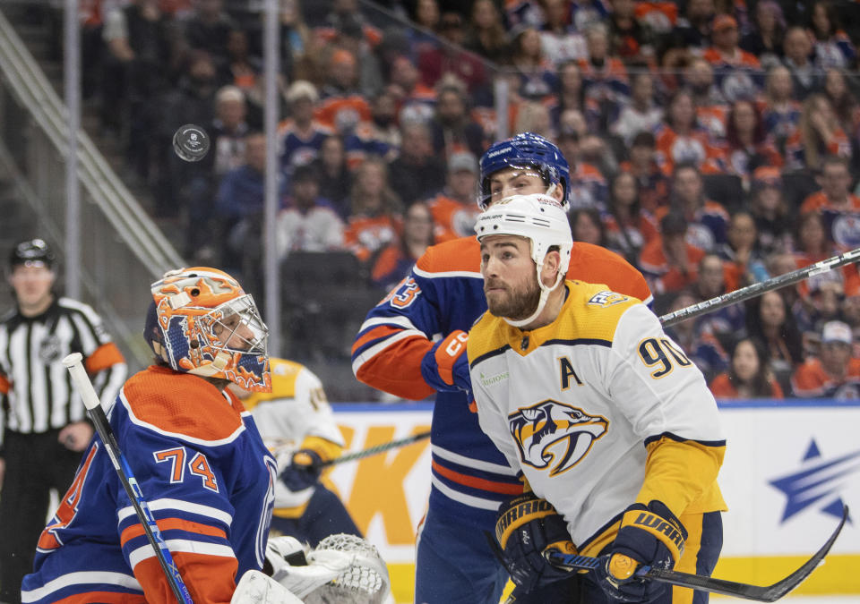 Nashville Predators' Ryan O'Reilly (90) watches the puck with Edmonton Oilers' Ryan Nugent-Hopkins (93) as Oilers goalie Stuart Skinner (74) looks on during first-period NHL hockey game action in Edmonton, Alberta, Saturday, Jan. 27, 2024. (Amber Bracken/The Canadian Press via AP)