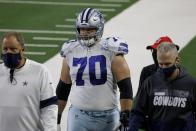 Dallas Cowboys guard Zack Martin (70) is escorted off the field after suffering an unknown injury in the first half of an NFL football game against the Arizona Cardinals in Arlington, Texas, Monday, Oct. 19, 2020. (AP Photo/Ron Jenkins)