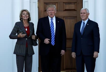 U.S. President-elect Donald Trump (C) and Vice President-elect Mike Pence stand with Betsy DeVos (L) before their meeting at the main clubhouse at Trump National Golf Club in Bedminster, New Jersey, U.S., November 19, 2016. REUTERS/Mike Segar