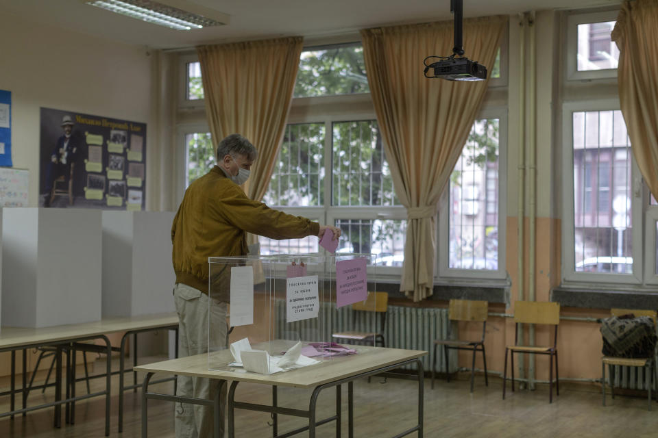 A man casts his ballot at a polling station in Belgrade, Serbia, Sunday, June 21, 2020. Serbia's ruling populists are set to tighten their hold on power in a Sunday parliamentary election held amid concerns over the spread of the coronavirus in the Balkan country and a partial boycott by the opposition. (AP Photo/Marko Drobnjakovic)