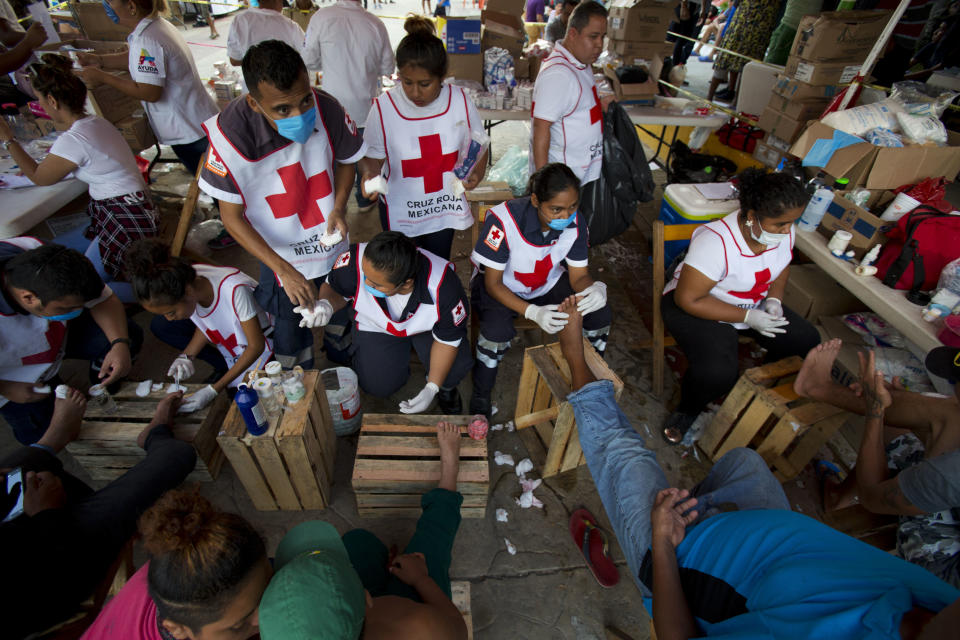 FILE - In this Oct. 26, 2018 file photo, Mexican Red Cross volunteers treat the blistered and cut feet of Central American migrants whose caravan stopped for the night in Arriaga, Mexico. Tired, swollen and blistered feet are one of the biggest challenges for the thousands of Central American migrants making their way through southern Mexico in hopes of starting new lives in the United States. (AP Photo/Rebecca Blackwell, File)