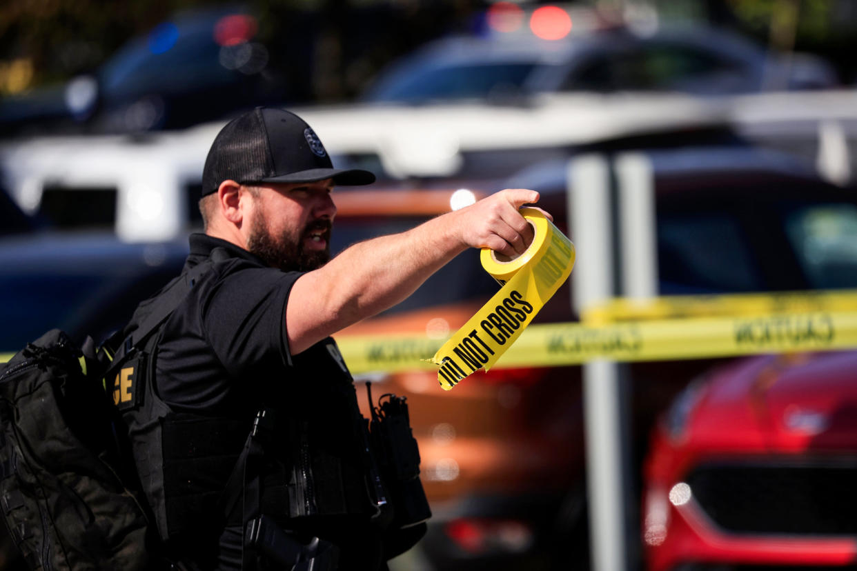 A police officer carries a roll of crime scene tape after a gunman opened fire at the Old National Bank building on April 10, 2023, in Louisville, Ky. (Luke Sharrett / Getty Images)