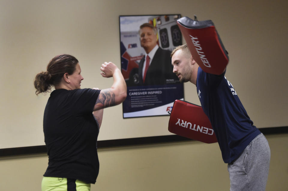 In this photo taken Sept. 10, 2019, Camille Carlon, left, and Ryan Russo go through a drill during a defensive tactic training class at the American Medical Response training center in Clackamas, Ore. Paramedics in Portland are undergoing mandatory training in defensive tactics after a rash of high-profile attacks against them as they respond to 911 calls for people in a mental health or drug-related crisis. (AP Photo/Steve Dykes)