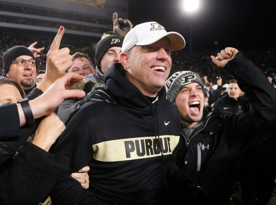 Head coach Jeff Brohm is mobbed by the Purdue faithful after the Boilermakers upset No. 2 ranked Ohio State 49-20 Saturday, October 20, 2018, at Ross-Ade Stadium. 