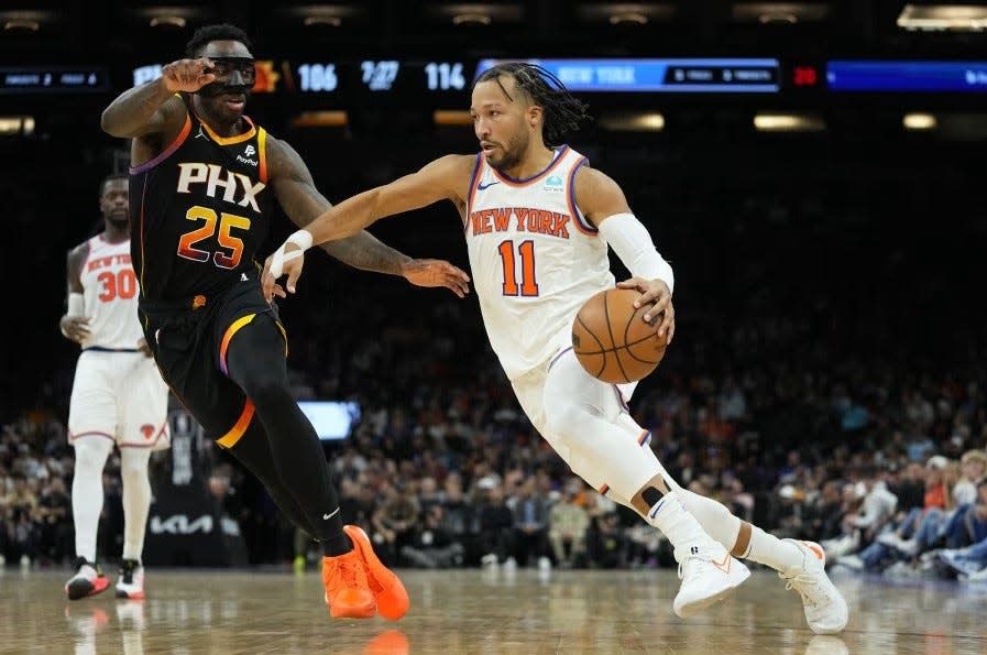 New York Knicks guard Jalen Brunson (11) drives as Phoenix Suns forward Nassir Little (25) defends during the second half of an NBA basketball game on Dec. 15, 2023, in Phoenix.