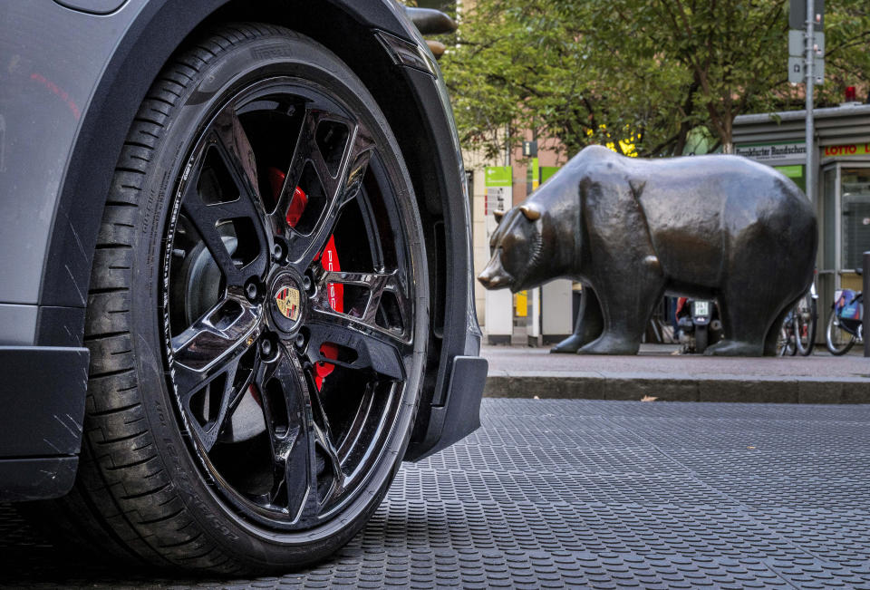 An electric Porsche Taycan is parked behind the bear statue in front of the stock market in Frankfurt, Germany, Wednesday, Sept. 28, 2022. German automaker Volkswagen is holding a share offering for a minority stake in its luxury division, Porsche. The shares are expected to start trading Thursday. (AP Photo/Michael Probst)