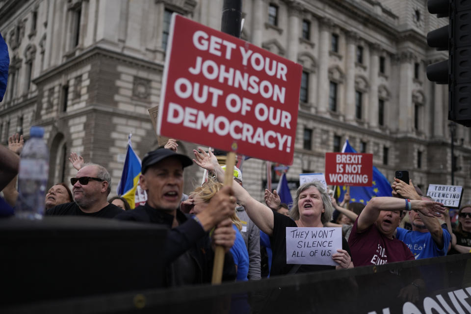 FILE - Anti-Brexit protesters sing to music standing on a traffic island across the street from the Houses of Parliament, in London, Wednesday, June 29, 2022. Britain is one of the world's oldest democracies, but some worry that essential rights and freedoms are under threat. They point to restrictions on protest imposed by the Conservative government that have seen environmental activists jailed for peaceful but disruptive actions. (AP Photo/Matt Dunham, File)