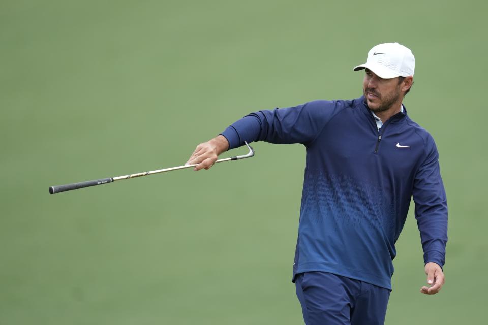 Brooks Koepka hands over his club on the second hole during a practice round in preparation for the Masters golf tournament at Augusta National Golf Club Tuesday, April 9, 2024, in Augusta, Ga. (AP Photo/Ashley Landis)