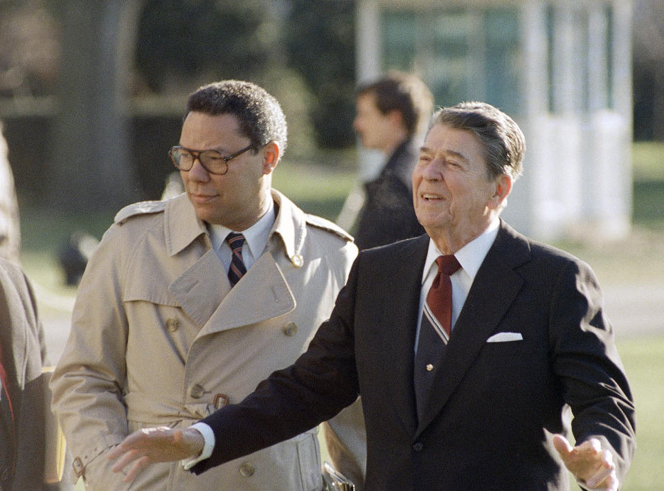 FILE - President Ronald Reagan, accompanied by national security adviser Colin Powell, leaves the White House in Washington, Dec. 16, 1988. Powell, former Joint Chiefs chairman and secretary of state, has died from COVID-19 complications. In an announcement on social media Monday, Oct. 18, 2021 the family said Powell had been fully vaccinated. He was 84. (AP Photo/Barry Thumma)