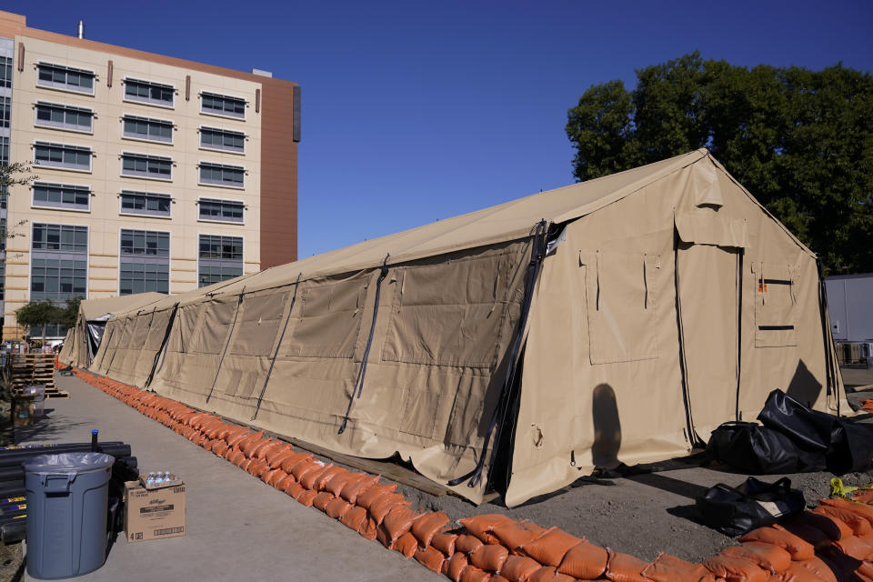 A mobile field hospital is set up at UCI Medical Center, Monday, Dec. 21, 2020, in Orange, Calif. California's overwhelmed hospitals are setting up makeshift extra beds for coronavirus patients, and a handful of facilities in hard-hit Los Angeles County are drawing up emergency plans in case they have to limit how many people receive life-saving care. (AP Photo/Jae C. Hong)
