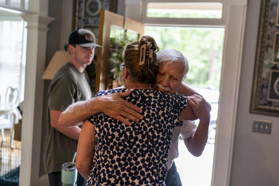 Janet Paulsen hugs her father, Ralph, goodbye as her son, Hunter, 20, looks on in their Acworth, Ga., home, Monday, Aug. 7, 2023. Janet grew up near Chicago and moved to Georgia for college. (AP Photo/David Goldman)