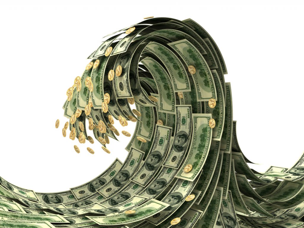 Dollar bills and gold coins arranged as a wave