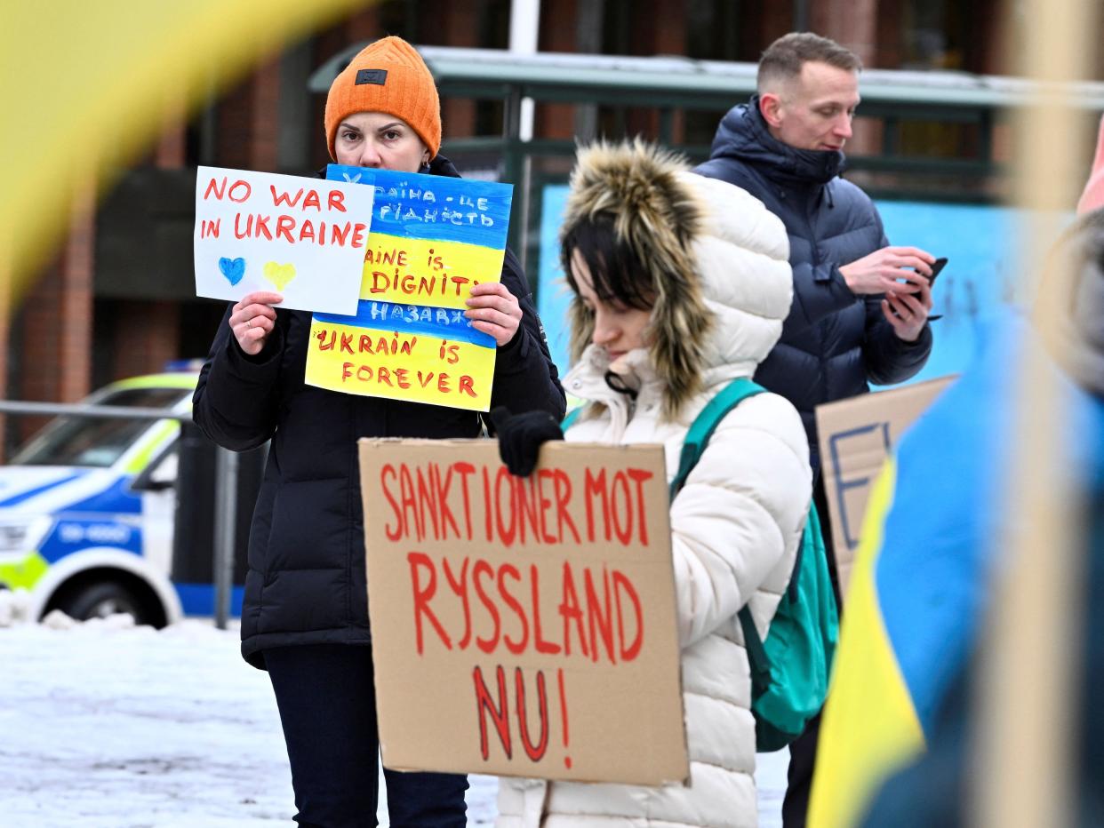 A protester holds a poster reading "Sanctions against Russia now" during a rally in front of the Russian Embassy in Stockholm on February 24, 2022, after Russia launched military operations in Ukraine.
