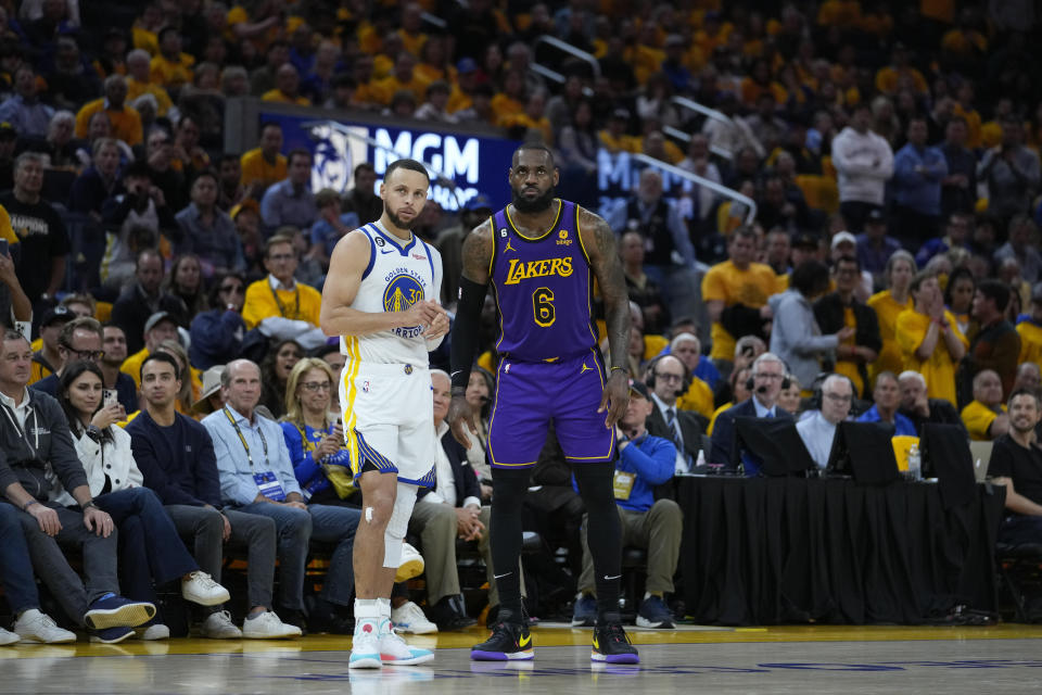 Golden State Warriors guard Stephen Curry, left, and Los Angeles Lakers forward LeBron James stand on the court during the second half of Game 2 of an NBA basketball Western Conference semifinal game in San Francisco, Thursday, May 4, 2023. (AP Photo/Godofredo A. Vásquez)
