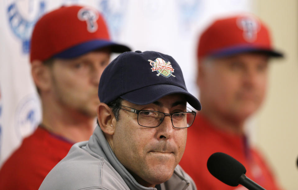 Philadelphia Phillies general manager Ruben Amaro Jr., center, speaks during a news conference as pitcher A.J. Burnett, left, and manager Ryne Sandberg, right, look on following a spring training baseball practice on Sunday, Feb. 16, 2014, in Clearwater, Fla. (AP Photo/Charlie Neibergall)