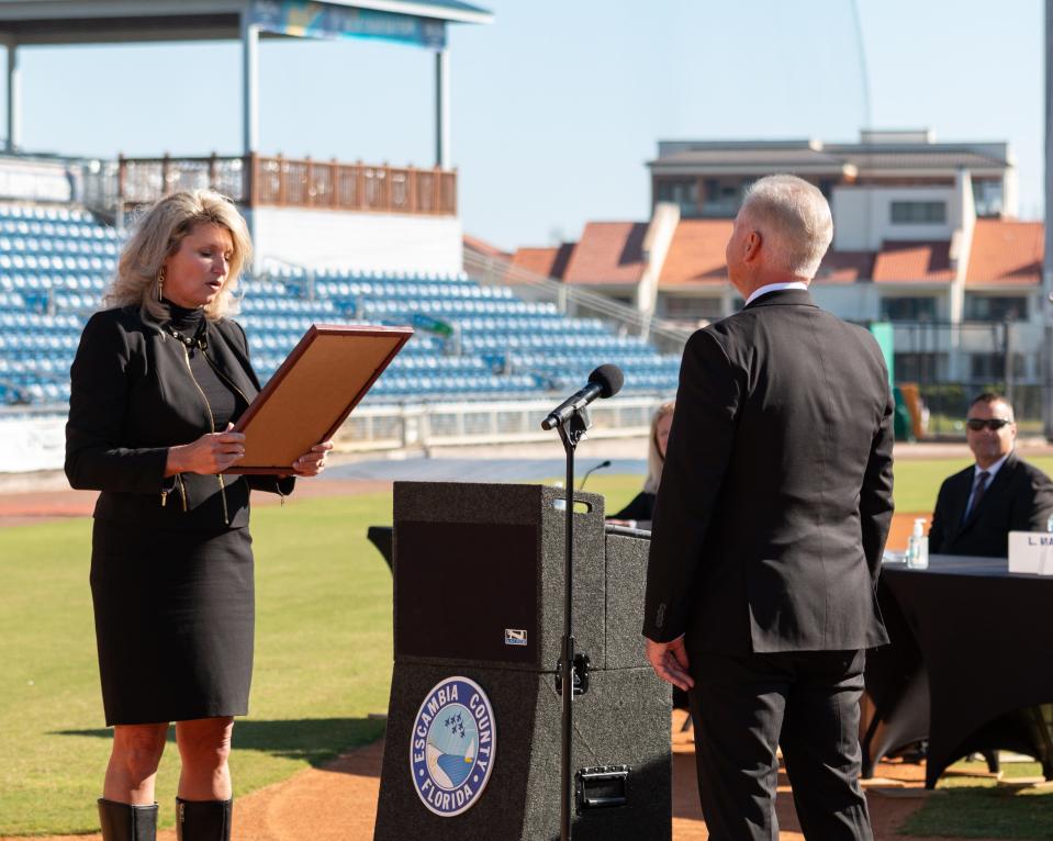 Escambia County Clerk and Comptroller Pam Childers, seen here reading the commission from Gov. Ron DeSantis to Commissioner Jeff Bergosh after he took his oath of office Tuesday, Nov. 17, 2020, faces a county lawsuit attempting to force Childers to authorize payments to three county commissioners' private retirement accounts.