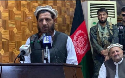 Mullah Abdul Basir, alleged to be the kidnapper of Linda Norgrove, stands in front of an Afghan flag - Credit: Kunar police