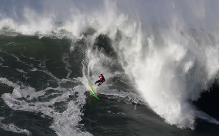 FILE PHOTO: A surfer drops in on a large wave at Praia do Norte in Nazare, Portugal December 30, 2017. REUTERS/Rafael Marchante/File Photo