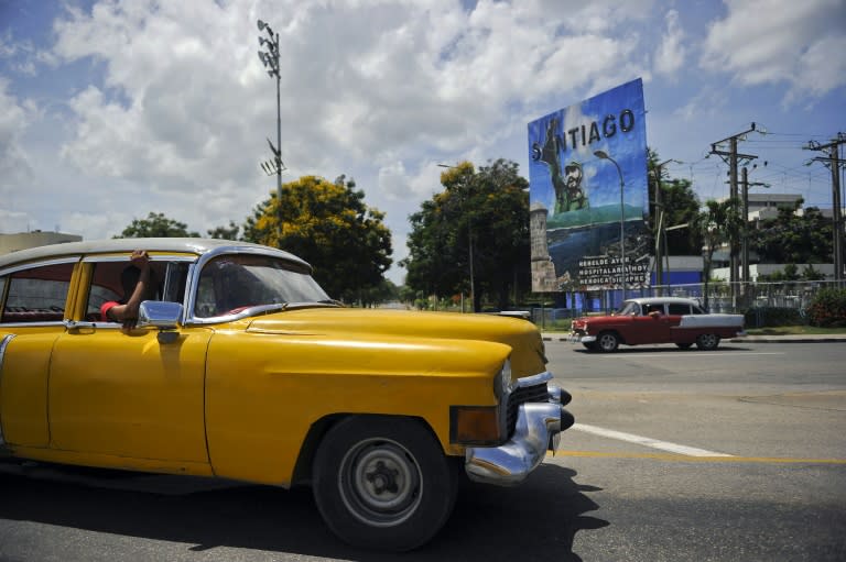 A classic American car drives past a banner depicting Fidel Castro on November 23 in Santiago de Cuba, where the late Cuban leader's ashes are interred