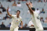 FILE - Australia's Pat Cummins, left, celebrates after taking the wicket of India's Cheteshwar Pujara during play on day two of the second cricket test between India and Australia at the Melbourne Cricket Ground, Melbourne, Australia on Dec. 27, 2020. Cummins was named as the new Australian team captain, Friday, Nov. 26, 2021 after the resignation of former captain Tim Paine, Friday, Nov. 19. (AP Photo/Asanka Brendon Ratnayake, File)