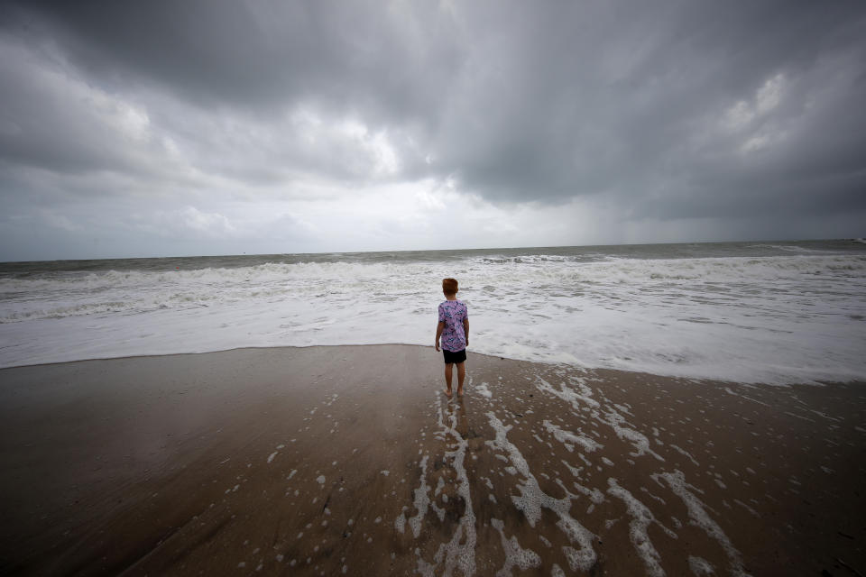 Weston Lee, of Vero Beach, stands near the high surf from the Atlantic Ocean, in advance of the potential arrival of Hurricane Dorian, in Vero Beach, Fla., Monday, Sept. 2, 2019. (AP Photo/Gerald Herbert)