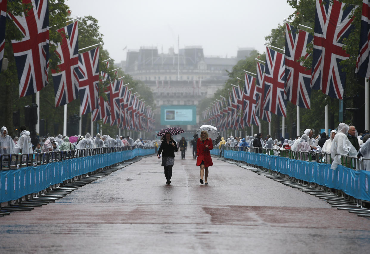 Guests walk down the Mall in the rain as they attend the Patron's Lunch, an event to mark Britain's Queen Elizabeth's 90th birthday, in London, June 12, 2016. REUTERS/Peter Nicholls 