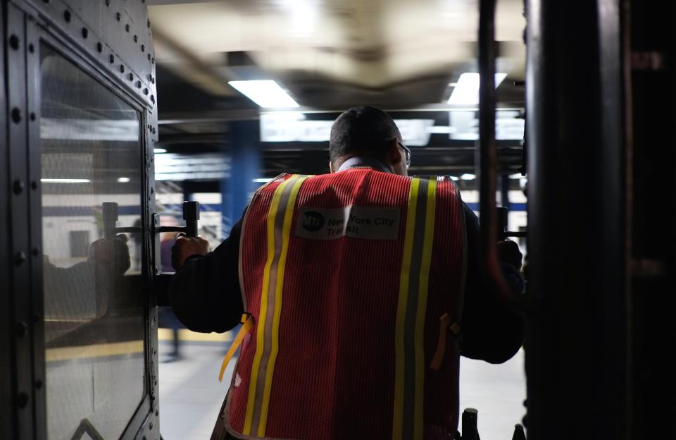 NEW YORK, NY - DECEMBER 16: A conductor stands between cars as a vintage New York City subway leaves the station on December 16, 2012 in New York City. The New York Metropolitan Transportation Authority (MTA) runs vintage subway trains from the 1930's-1970's each Sunday along the M train route from Manhattan to Queens through the first of the year. (Photo by Preston Rescigno/Getty Images)