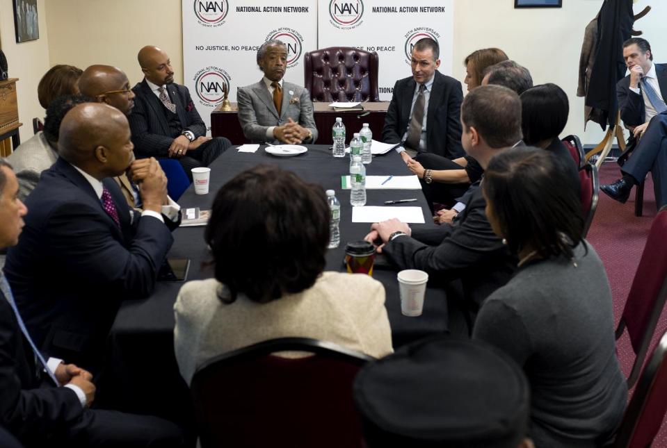 The Rev. Al Sharpton, top center left, listens to Mark Lee, top center right, CEO of Barneys New York, Tuesday, Oct. 29, 2013, at the National Action Headquarters in New York, to discuss allegations of racial profiling after customers who were arrested outside the store after making legal purchases. Two black customers recently claimed they were detained by police on suspicion of credit card fraud after lawfully purchasing expensive items. (AP Photo/Craig Ruttle)