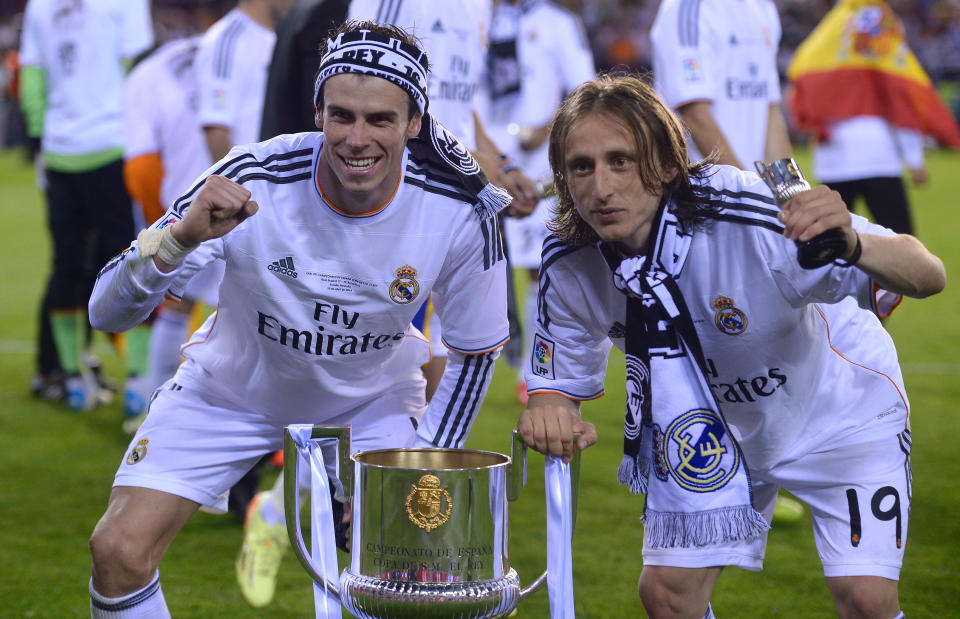 Real's Gareth Bale, left, and Luka Modric celebrate with the trophy at the end of the final of the Copa del Rey between FC Barcelona and Real Madrid at the Mestalla stadium in Valencia, Spain, Wednesday, April 16, 2014. Real defeated Barcelona 2-1. (AP Photo/Manu Fernandez)