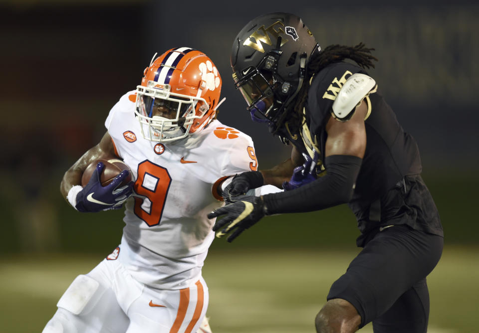 Clemson running back Travis Etienne, left, is taken down by Wake Forest's Ja'Sir Taylor after a long run in the first half of an NCAA college football game Saturday, Sept. 12, 2020, in Winston-Salem, N.C. (Walt Unks/The Winston-Salem Journal via AP)