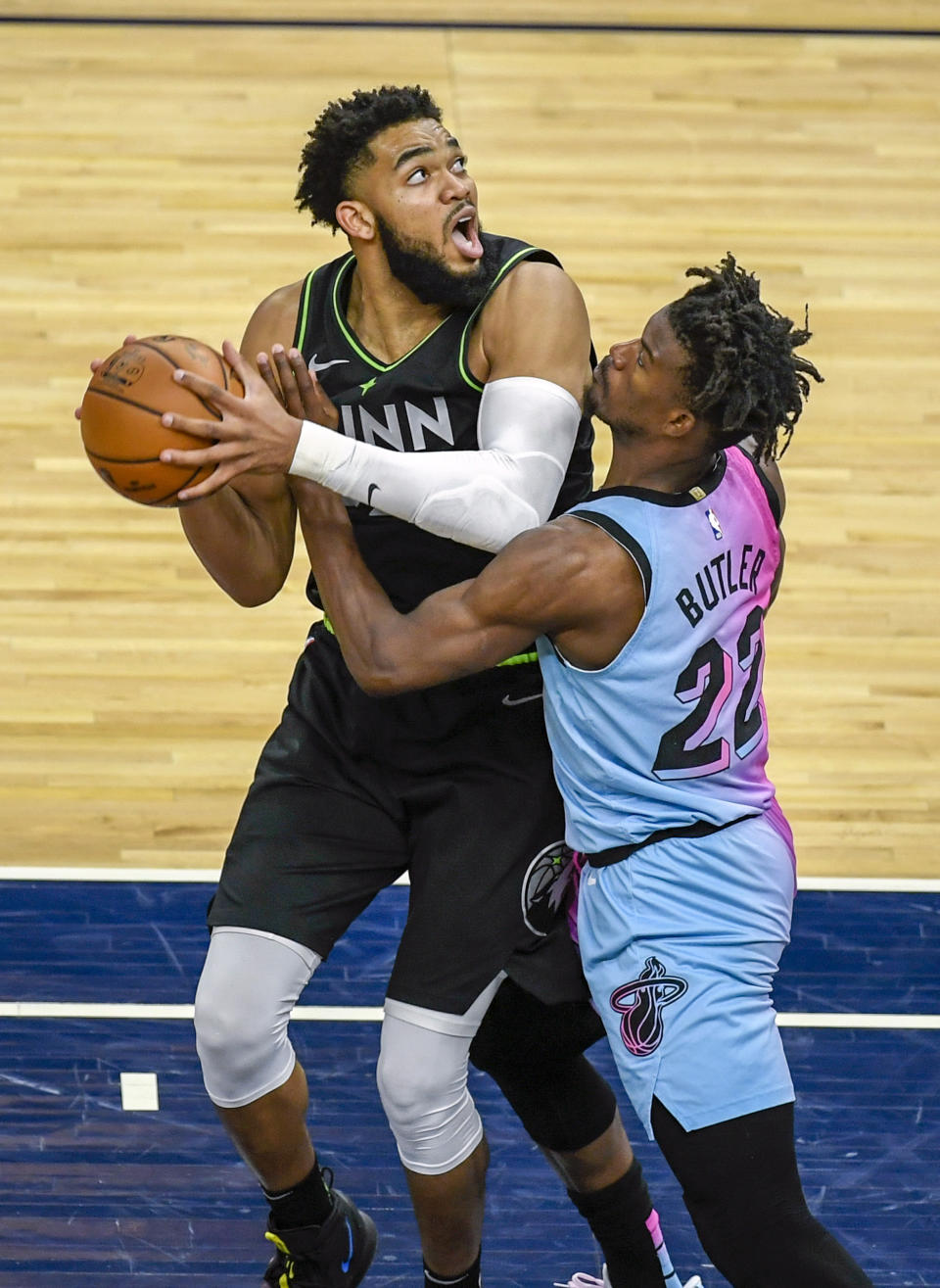 Minnesota Timberwolves center Karl-Anthony Towns, left, is fouled by Miami Heat forward Jimmy Butler during the second half of an NBA basketball game Friday, April 16, 2021, in Minneapolis. The Timberwolves won 119-111. (AP Photo/Craig Lassig)