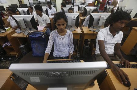 Students who lost their families in the 2004 Tsunami take part in a computer class at the Foundation of Goodness village project in Seenigama December 20,2014. REUTERS/Dinuka Liyanawatte