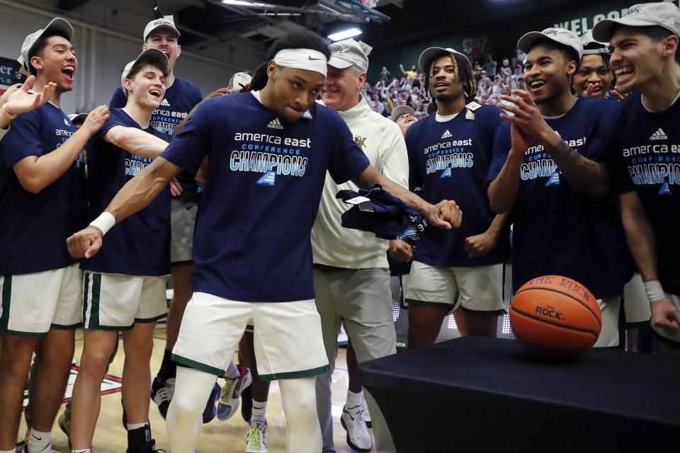 Vermont's Dylan Penn, center left, reacts to being named MVP after Vermont defeated UMass Lowell during an NCAA college basketball game in the final of the America East Conference Tournament, Saturday, March 11, 2023, in Burlington, Vt. (AP Photo/Michael Dwyer)