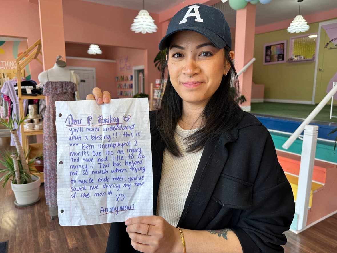 Wolf and Rebel founder Annie Vanrivong shows a letter left in the Girl Up UWindsor Period Pantry outside her business. (Katerina Georgieva/CBC - image credit)