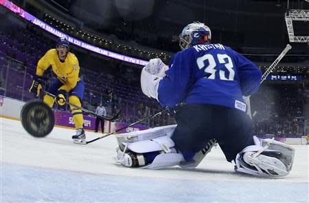 Sweden's Loui Eriksson (L) scores on Slovenia's goalie Robert Kristan during the third period of their men's quarter-finals ice hockey game at the Sochi 2014 Winter Olympic Games February 19, 2014. REUTERS/Martin Rose/Pool