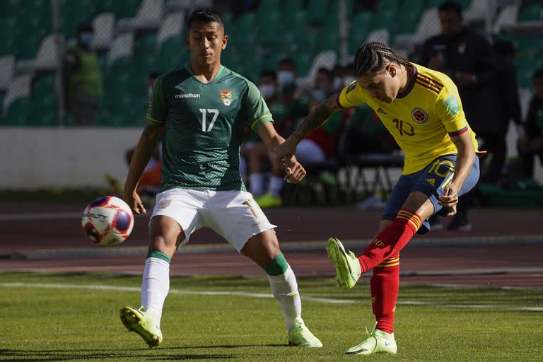 Colombia's Juan Quintero (R) strikes the ball as Bolivia's Roberto Carlos Fernandez looks on during their South American qualification football match for the FIFA World Cup Qatar 2022 at the Hernando Siles Olympic Stadium in La Paz on September 2, 2021. (Photo by Javier MAMANI / POOL / AFP)