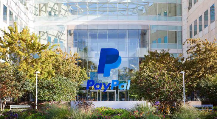 PYPL stock, PayPal logo overlays daylight photo of corporate building