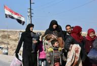 A Syrian family arrives at a checkpoint manned by pro-government forces after leaving Aleppo's eastern neighbourhoods on December 10, 2016