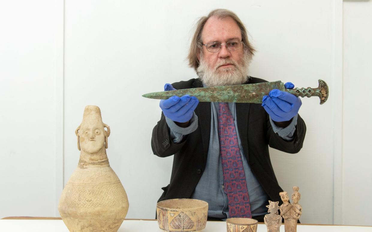 Curator St John Simpson with an Iron Age sword from north-west Iran, 9-10 Century BC , a medieval-Islamic pot from Kandahar and painted pots, 2-2,500 BC from Helmand Province - Geoff Pugh