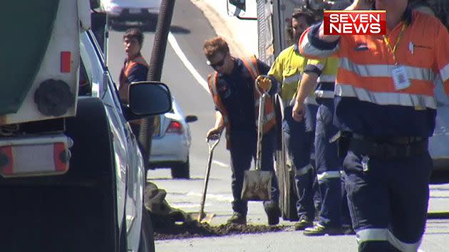 Crews clean waste after it spilled from a truck.