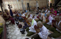 In this April 8, 2014 photo, men and boys with their clean-shaven heads participate in Buddhist rituals during a "shinbyu," or ordaining ceremony, at a Buddhist monastery in suburbs of Yangon, Myanmar. Though most boys only remain monks for a few days, the "shinbyu" or ordaining ceremony, followed by Myanmar Buddhists, is said to date back more than two and half millennium, a religious gift given by Buddha to his own son, Rahula. (AP Photo/Gemunu Amarasinghe)